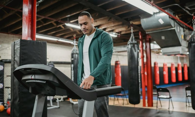 Man on treadmill walking using machine in gym