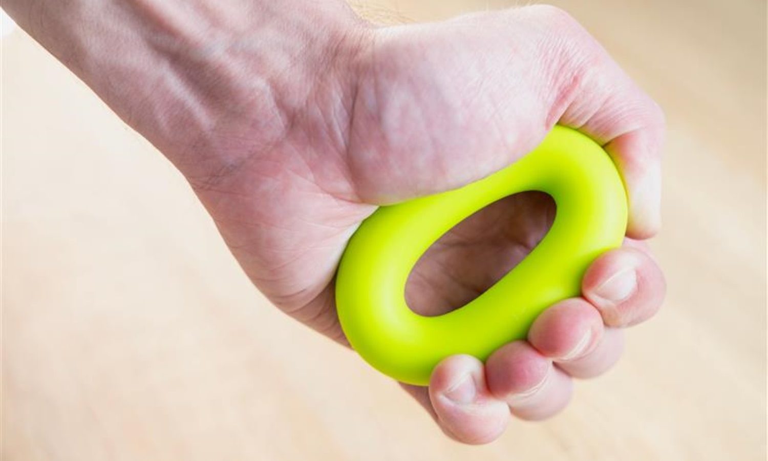 Man hand close-up squeezing the stress ball or grip strengthener