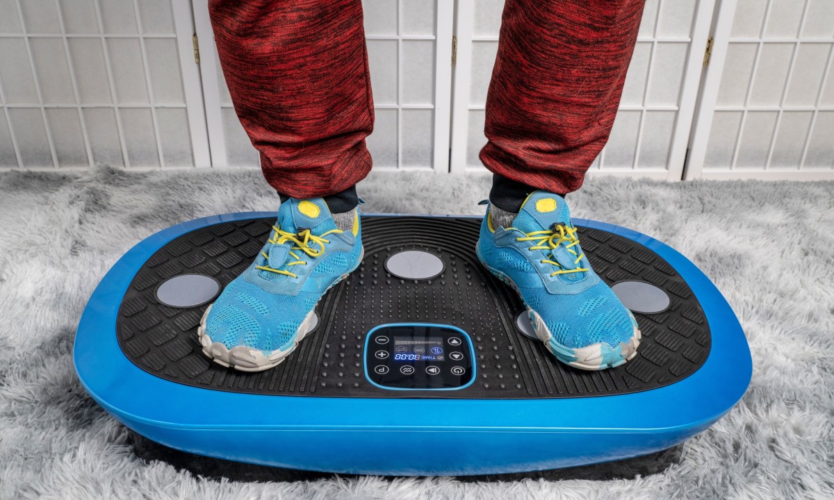 an blue sneakers on vibration plate working out indoors at home