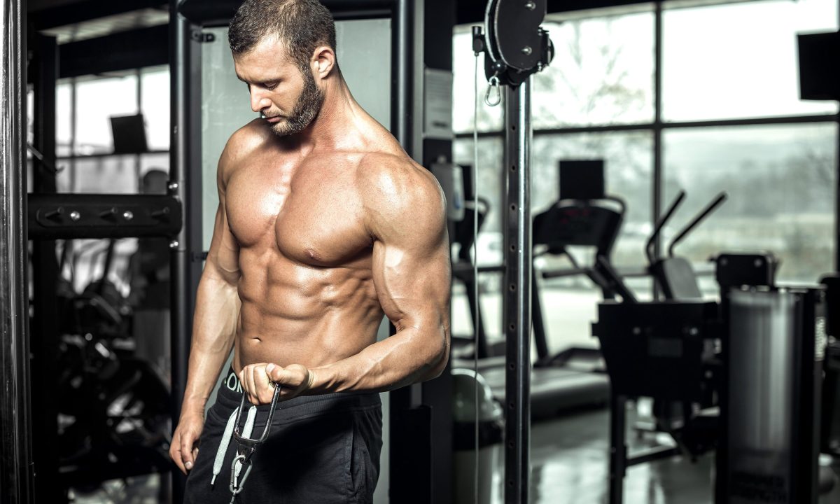 Man in the gym doing cable bicep curls on the cable machine