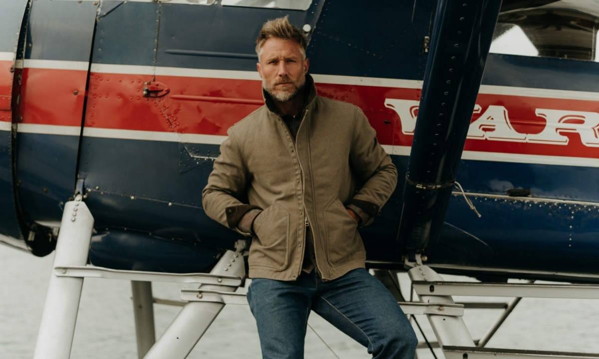 taylor stitch treadwell man in front of plane with chore coat