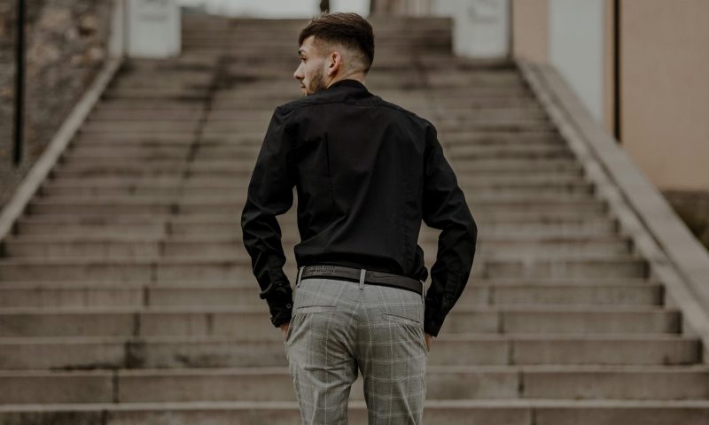 Man in suit pants walking up stairs