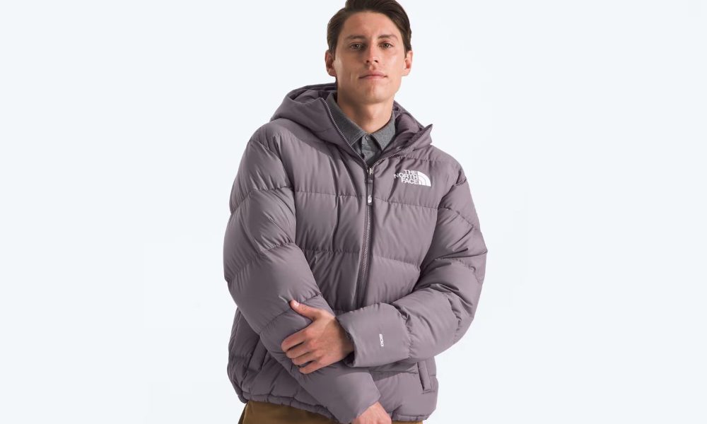 A man strikes a pose while wearing The North Face's Men's Frost Fall Hooded Jacket.