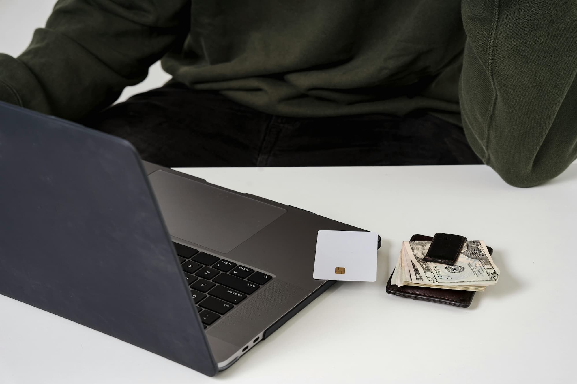 computer on table with credit card and wallet next to it