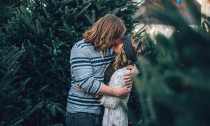 Couple kissing in front of tree