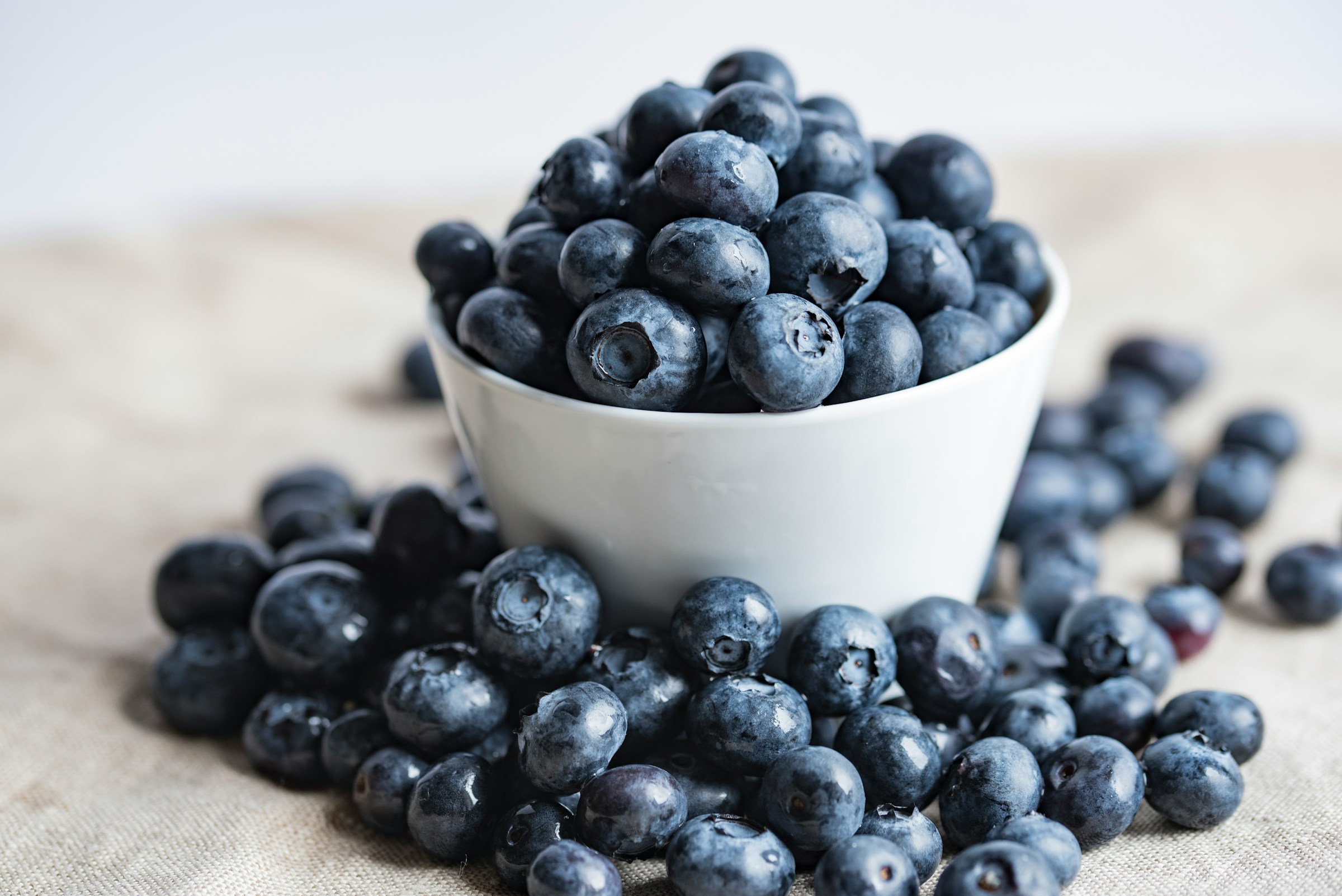 white bowl of blueberries on table