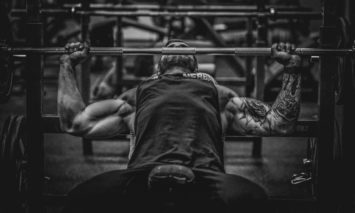 man lifting weights muscle bench press barbell black and white