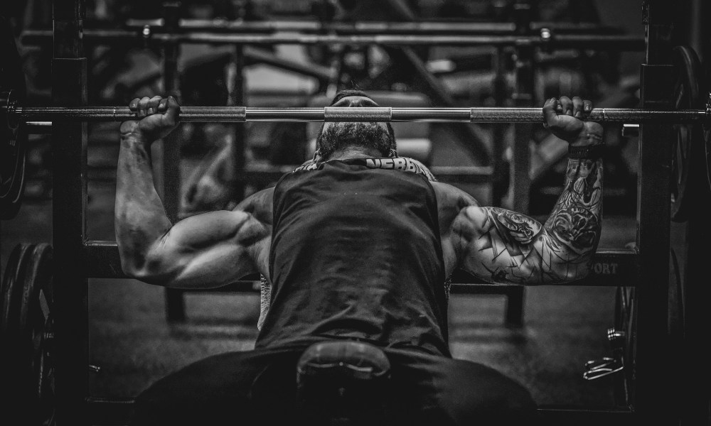 man lifting weights muscle bench press barbell black and white