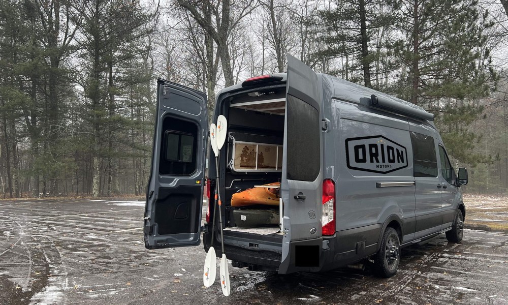 Orion 365 camper van parked outdoors with its rear doors open.