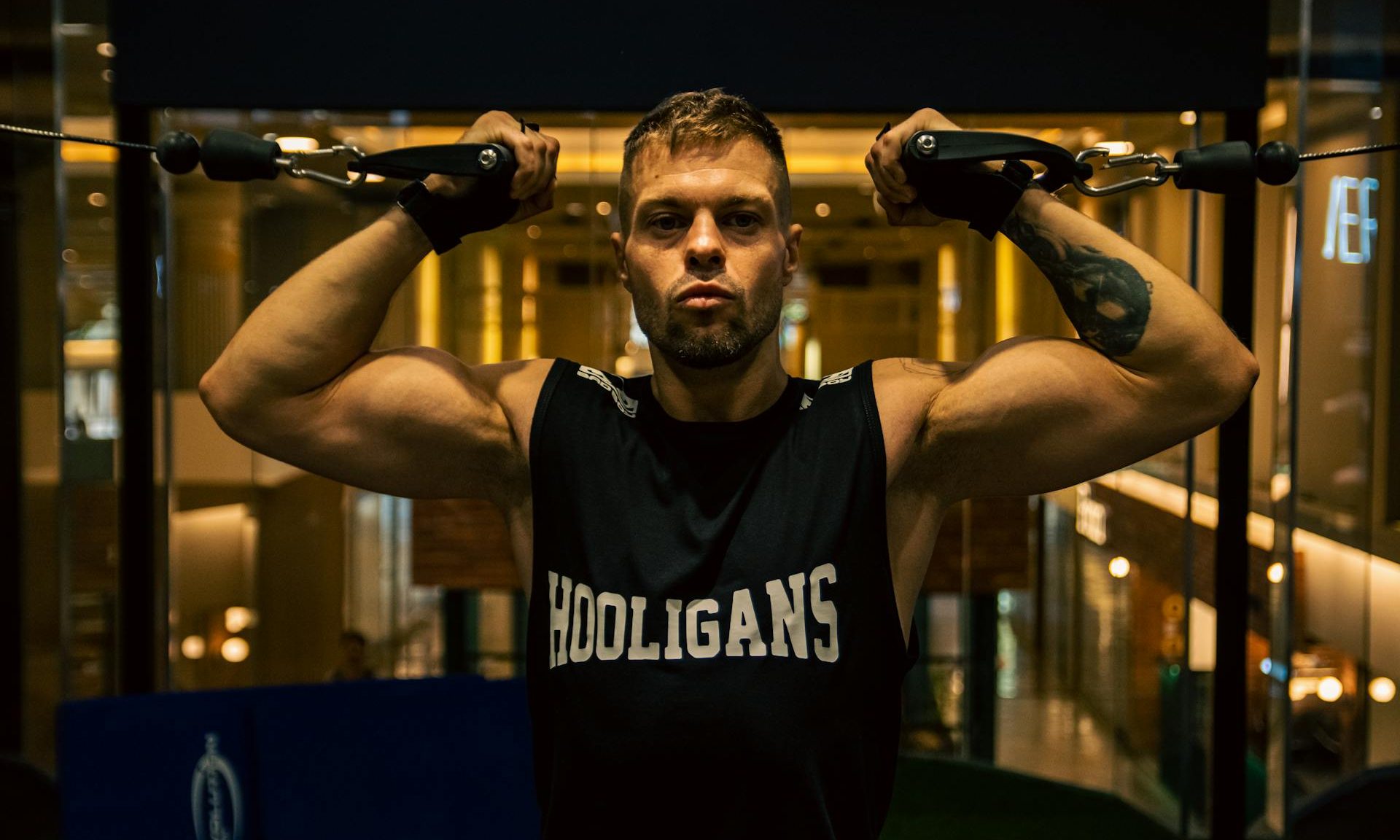 Man doing high cable bicep curl in gym with cable machine