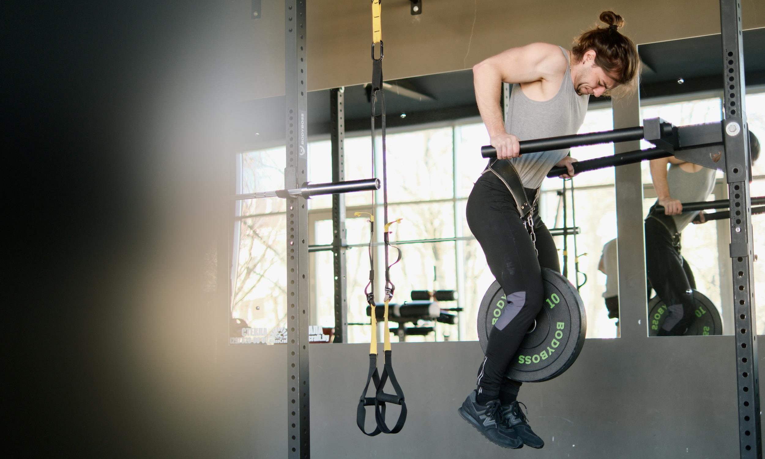 man doing tricep dip on parallel bars dip bars weighted dip in gym