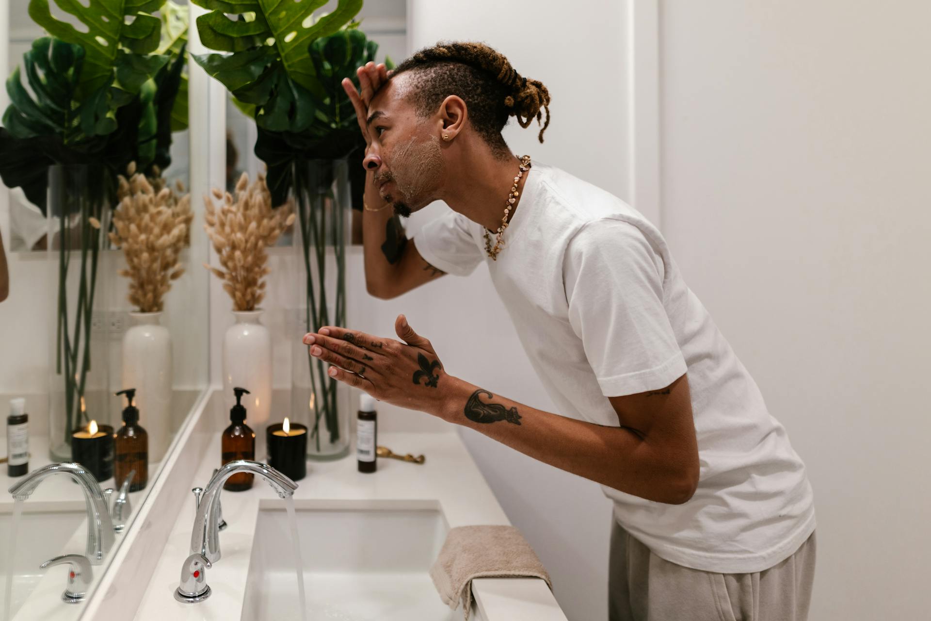 Man looking in the mirror using a skincare product