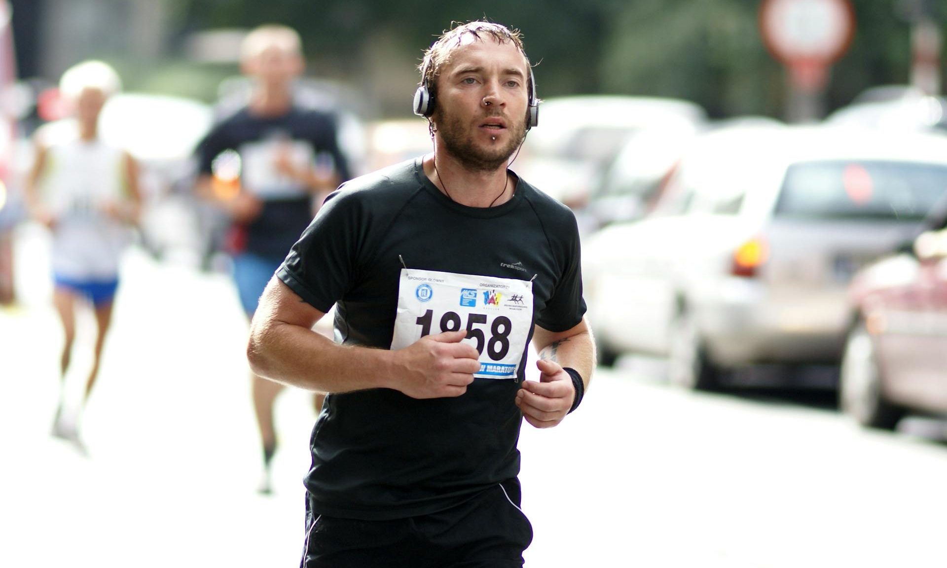 man running marathon headphones black t shirt outside