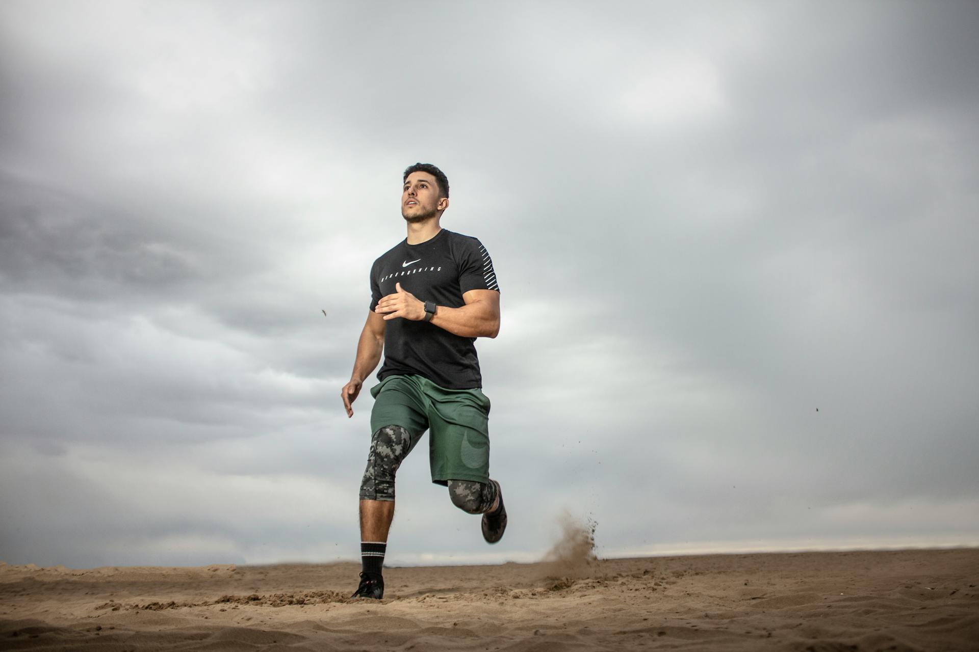 man exercising running around outdoors dark grey sky