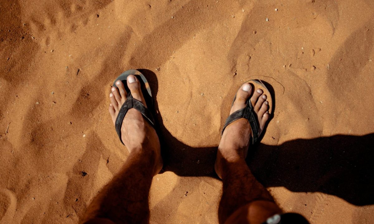feet with sandals on sand