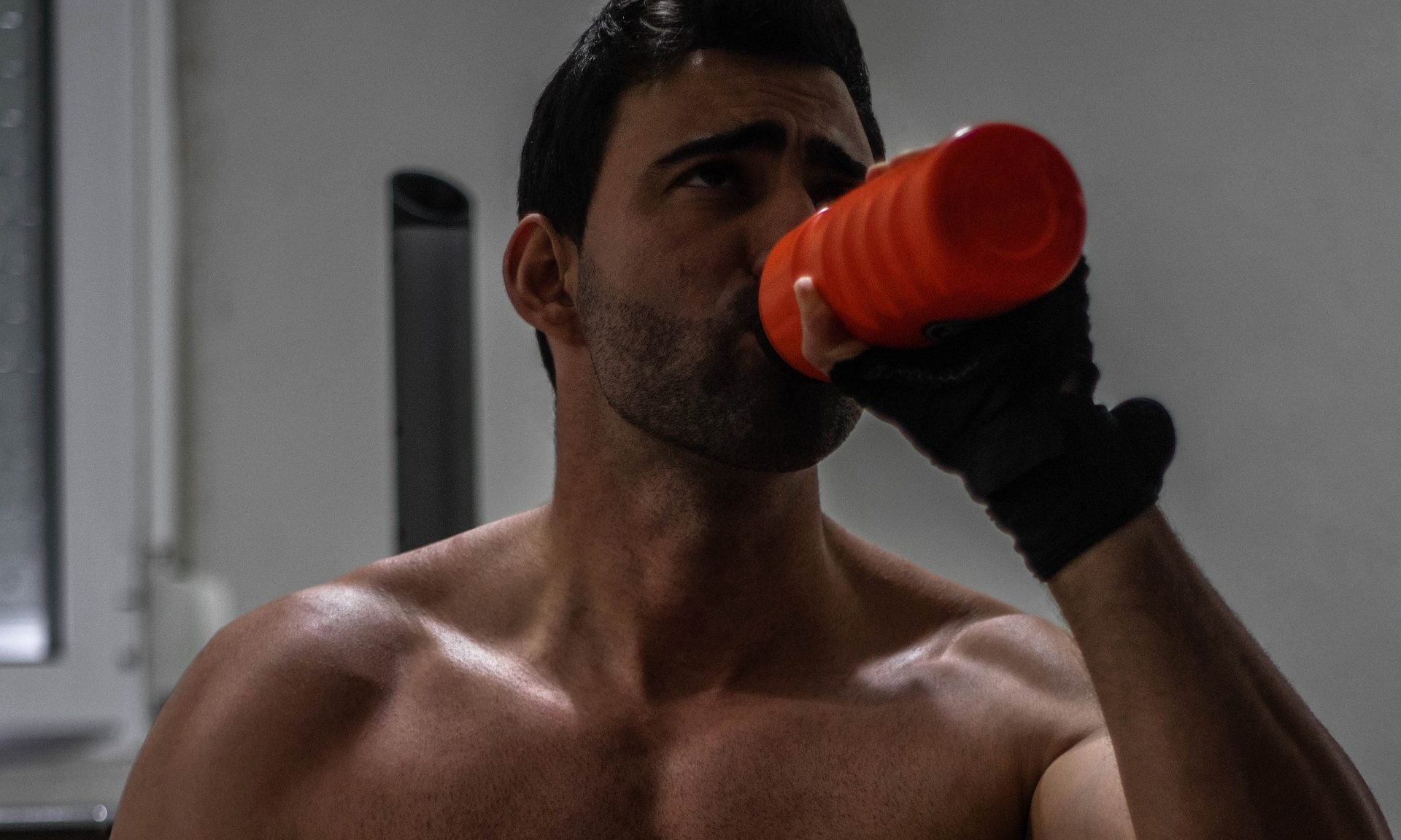 Shirtless man drinking protein shake drink muscle