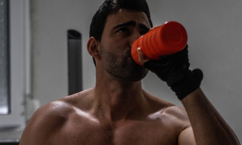 Shirtless man drinking protein shake drink muscle