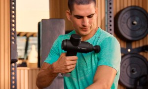 A man using the Hyperice Hypervolt 2 Pro Premium massage gun.