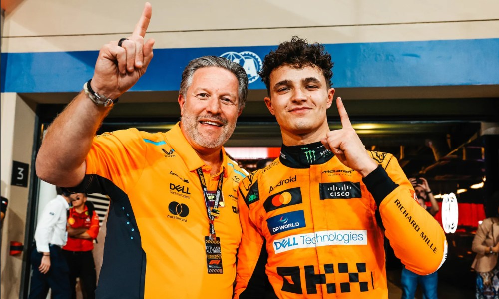 McLaren CEO Zak Brown and F1 driver Lando Norris in front of pit garage after Abu Dhabi Grand Prix after winning Constructors' Championship.