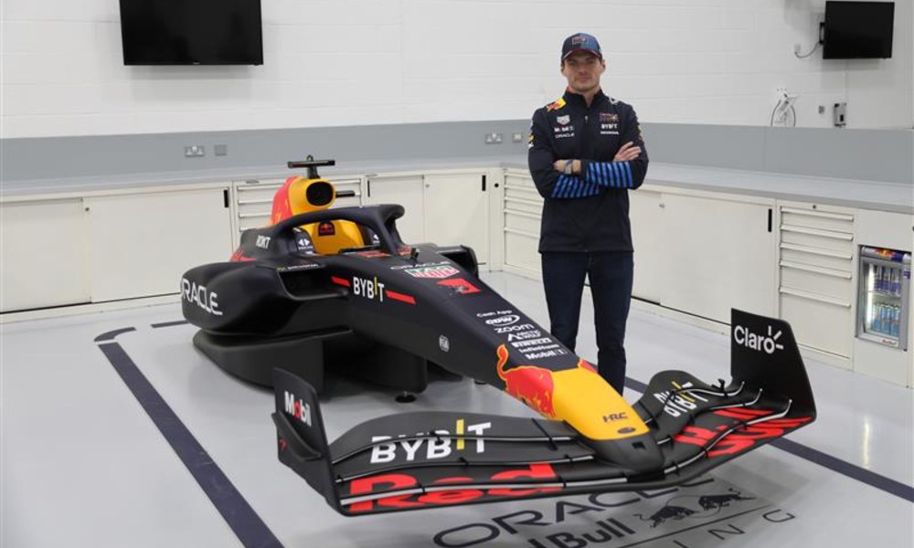 Red Bull F1 driver Max Verstappen standing next to Motion Simulator.