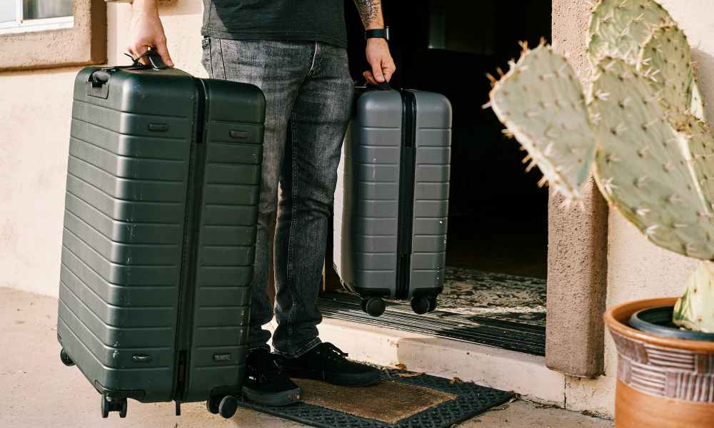 man carrying luggage in both hands