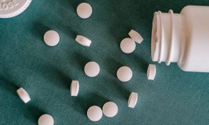 Magnesium supplement pill vitamin mineral on table by bottle