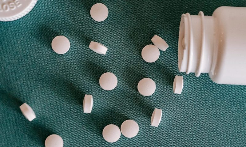 Magnesium supplement pill vitamin mineral on table by bottle