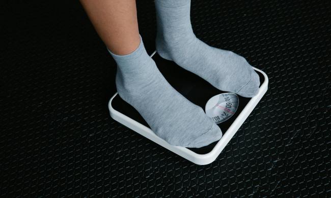 Standing on scale weighing body weight