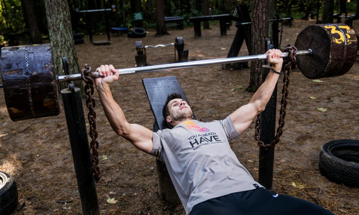 Man bench pressing outside
