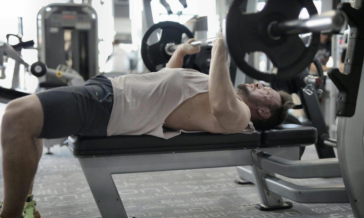 man doing bench press in gym resistance training