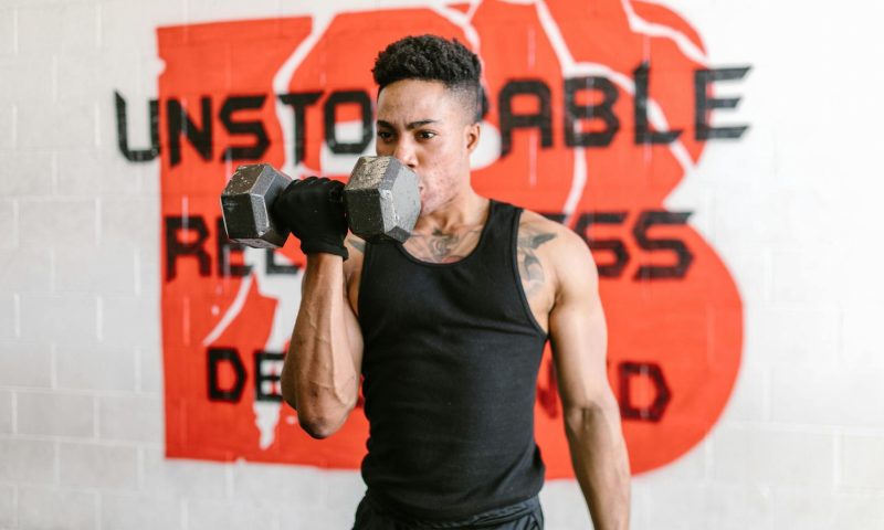 -man doing one arm unilateral bicep curl dumbbel