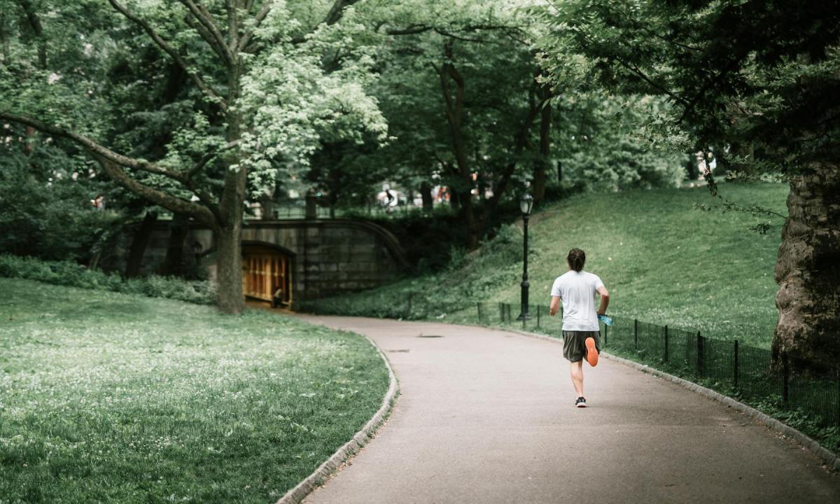 Man running jogging outdoors outside in nature on a path