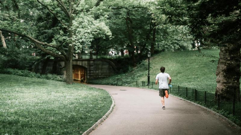 Man running jogging outdoors outside in nature on a path