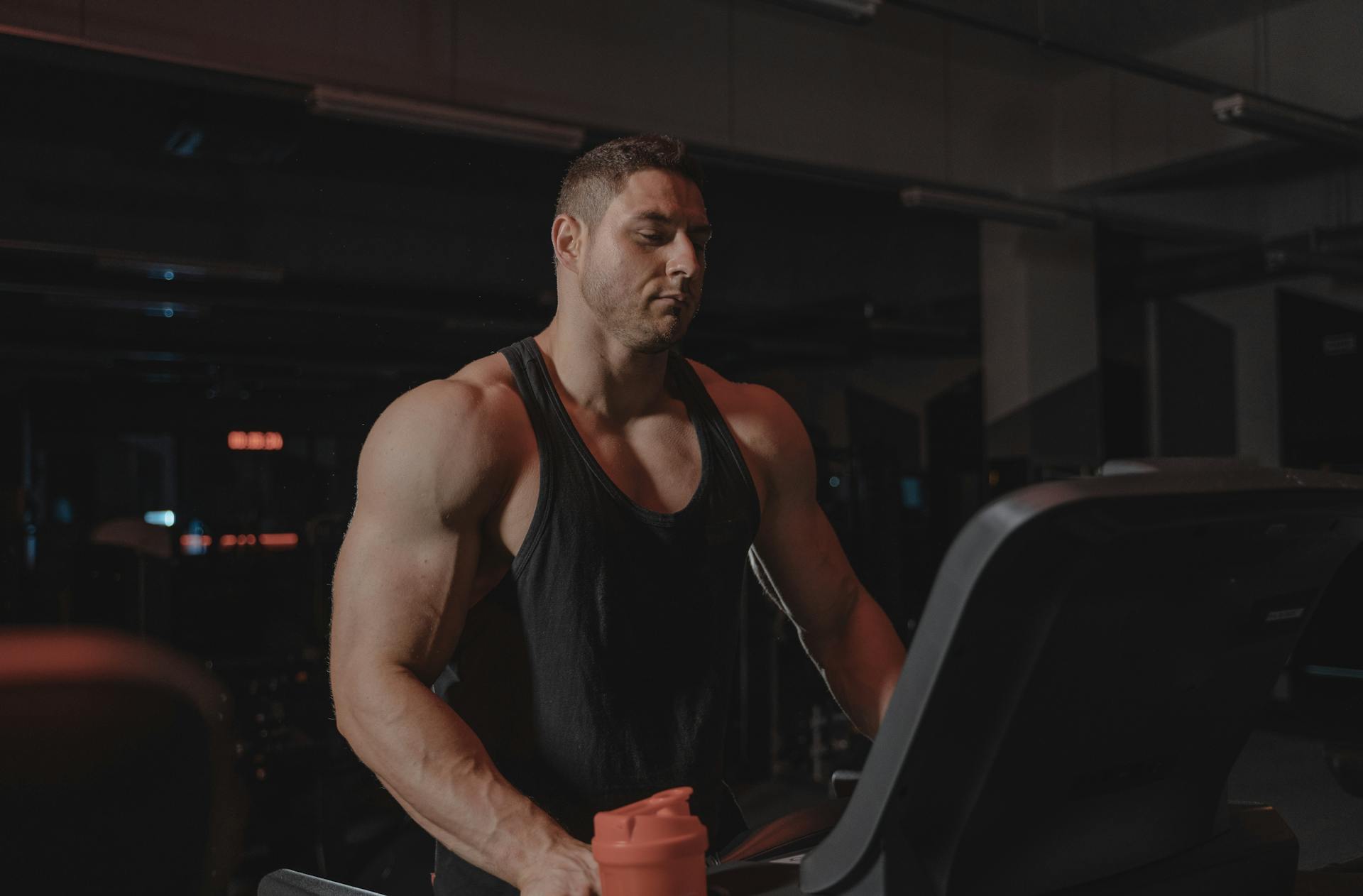muscular man on treadmill standing on treadmill in gym