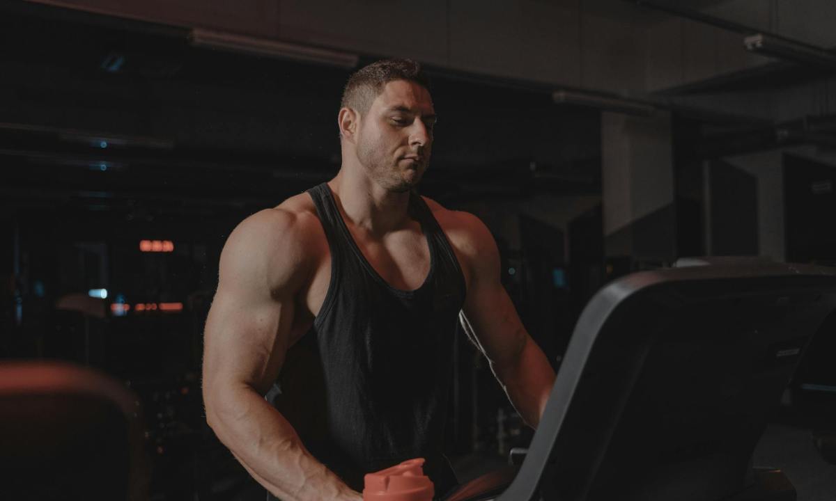 muscular man on treadmill standing on treadmill in gym