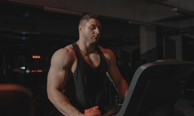 muscular man on treadmill standing on treadmill in gym