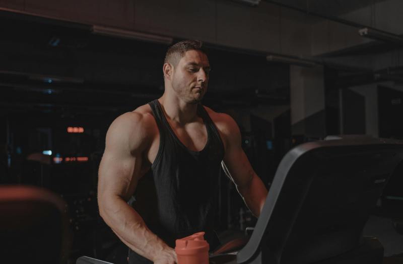 muscular man on treadmill standing on treadmill in gym