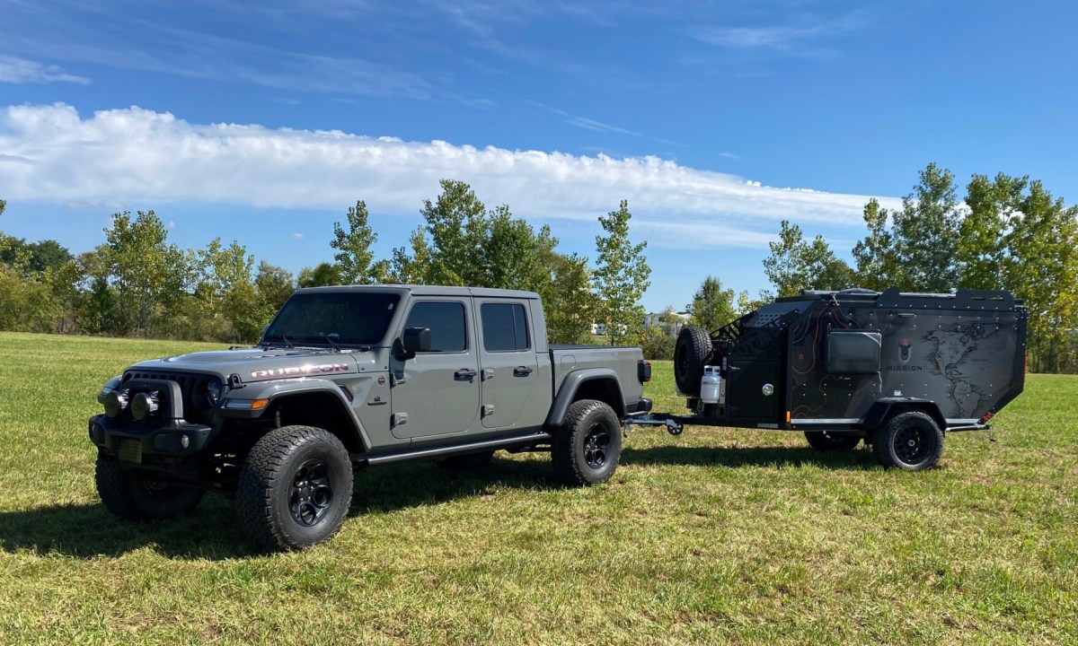 Mission Overland Trail Dog powersports towable camper parked in a field.
