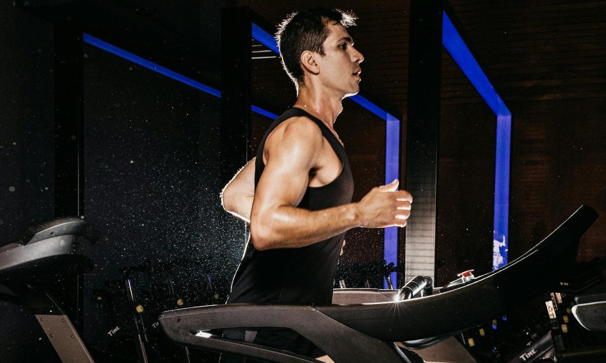 man running wearing black vest on treadmill cardio aerobic