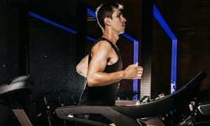 man running wearing black vest on treadmill cardio aerobic