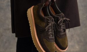 man holding brown sneakers
