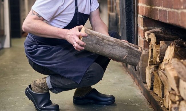 chef squatting in kitchen in clogs