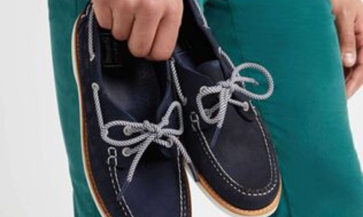 model holding navy blue boat shoes