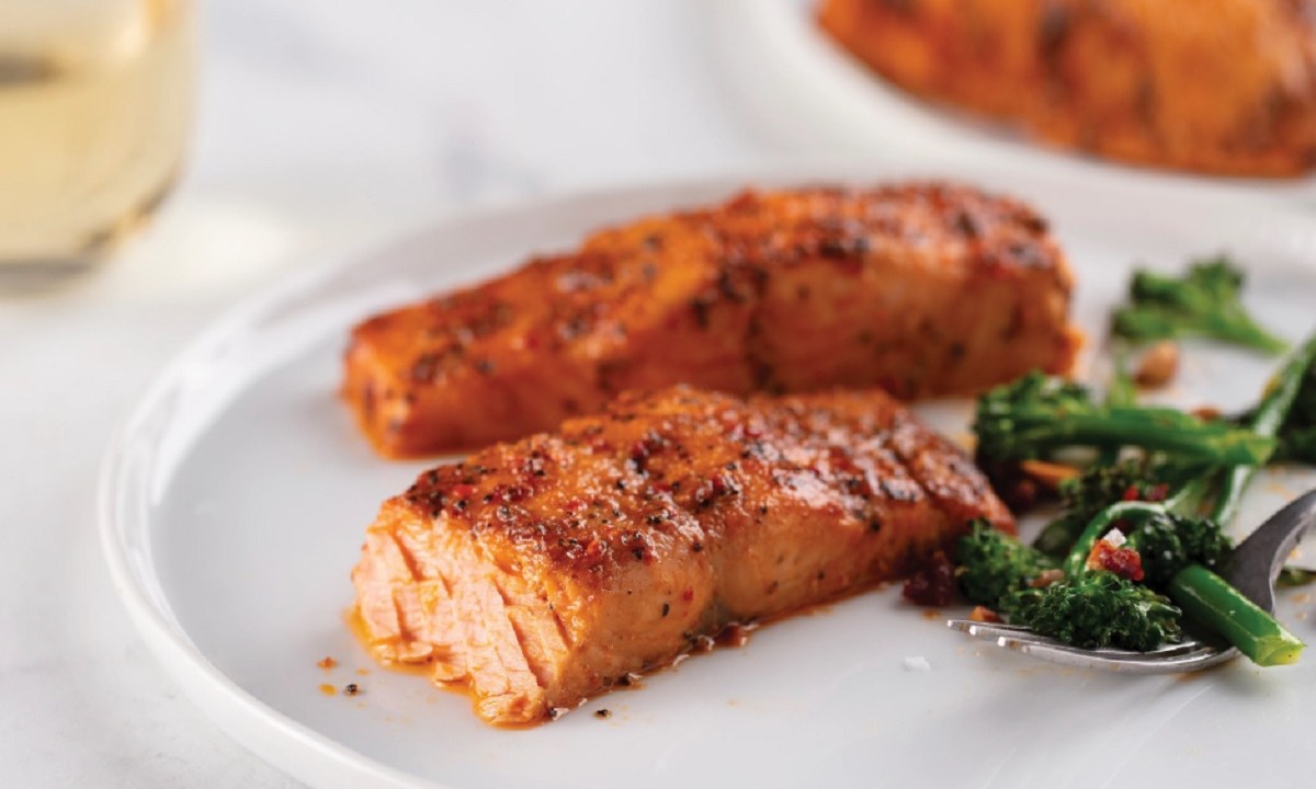 Two salmon fillets on a white plate