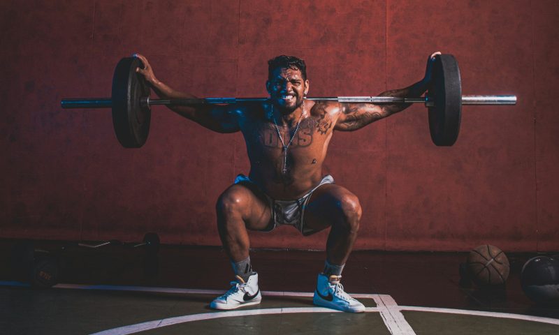 Man exercising hard pain barbell squat