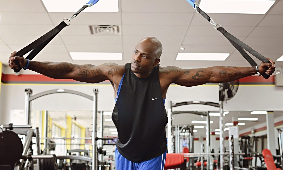 man in gym using bands thinking happy