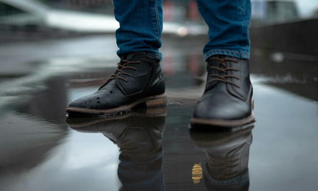 man wearing leather boots in rain puddle
