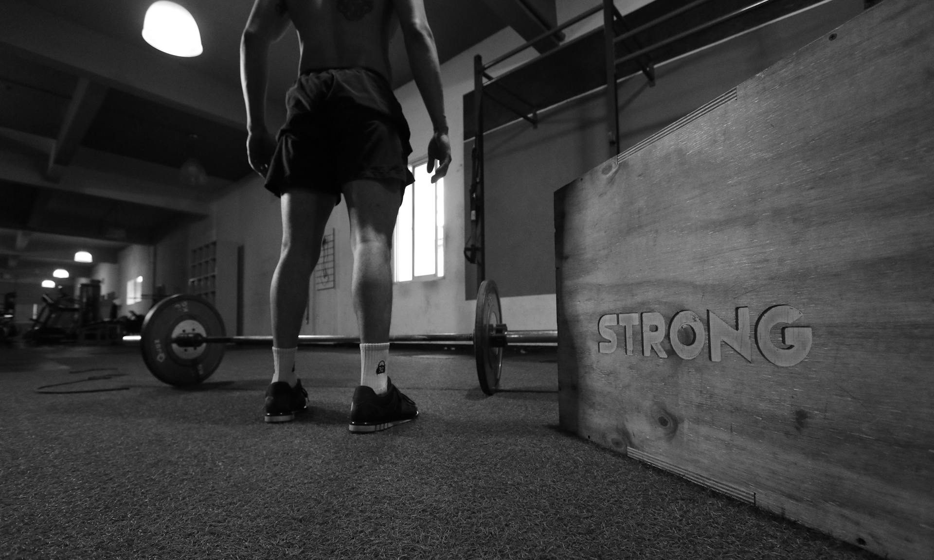 -man barbell on ground in gym strong