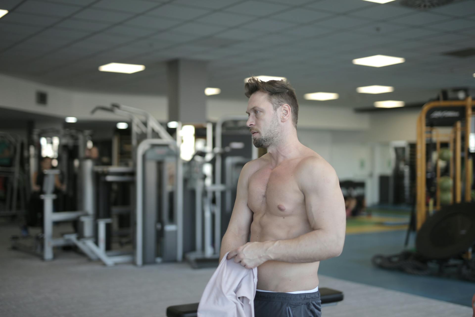 man took shirt off abs holding shirt in gym