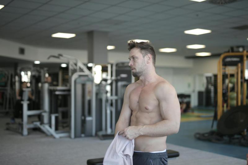 man took shirt off abs holding shirt in gym